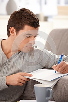 Portrait of college guy taking notes