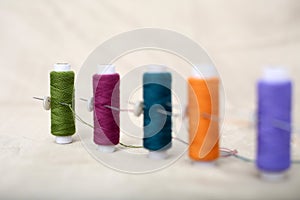 Portrait of colored sewing thread and needle on the cloth