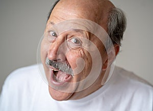 Portrait of comic and crazy senior man with funny face