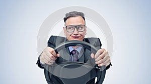 Portrait of a comical businessman in a dark suit and glasses holding a car steering wheel in his hands, on a light blue background