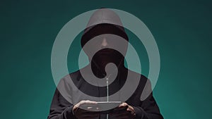 Portrait of computer hacker in hoodie. Obscured dark face. Data thief, internet fraud, darknet and cyber security .