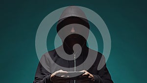 Portrait of computer hacker in hoodie. Obscured dark face. Data thief, internet fraud, darknet and cyber security .