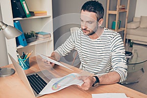 Portrait of concentrated businessman with laptop doing paperwork