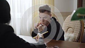 Portrait of concentrated depressed man looking at psychologist showing treatment plan on paper. Sad desperate Caucasian