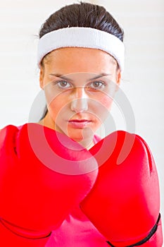 Portrait of concentrated fit girl in boxing gloves