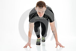 Portrait of a concentrated male sprinter preparing to start running
