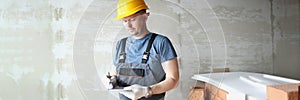 Concentrated male worker hold clipboard and write down needed work material for renovation