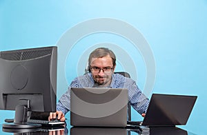 Portrait of concentrated man, programmer, computer system analyst working with operating sytem isolated over blue