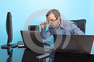 Portrait of concentrated man, programmer, computer system analyst working with operating sytem isolated over blue