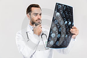 Portrait of concentrated young medical doctor working in hospital and holding X-ray scan