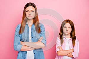 Portrait of concetrated friends crossing their hands looking isolated over pink background