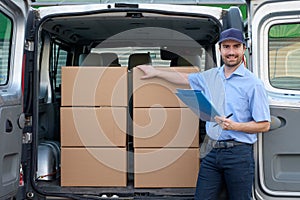 Portrait of confidence express courier next to his delivery van