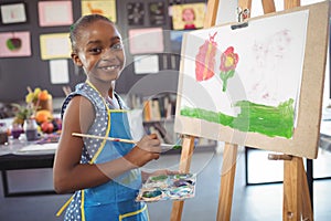 Portrait of confidence girl painting on canvas