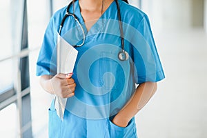 Portrait confident African American female doctor medical professional writing patient notes isolated on hospital clinic hallway