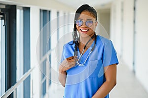 Portrait confident African American female doctor medical professional writing patient notes isolated on hospital clinic hallway