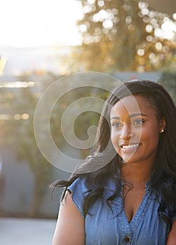 Portrait Of Confident African American Woman In Garden At Home Against Flaring Sun