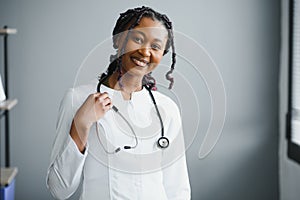 Portrait confident African female doctor medical professional writing patient notes isolated on hospital clinic hallway