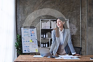 Portrait confident asian business woman standing at her desk on office