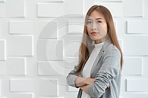 Portrait of a confident Asian business woman standing over white