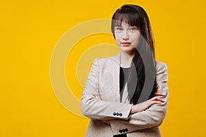 Portrait of confident attractive young business woman in suit with arms crossed