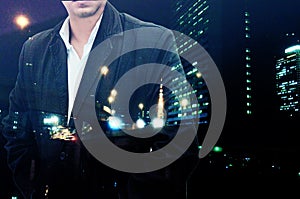 Portrait of a confident bearded businessman standing with his hands in pockets overlay night city landscape background . Double e