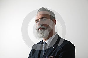 Portrait of confident bearded middle aged gentleman wearing trendy suit over empty white background. Studio shot