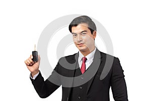 Portrait of a confident business man in black suit feeling happy and smile holding the keys of the car isolated on white