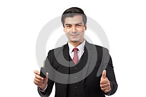 Portrait of a confident business man in black suit feeling happy and smile holding the keys of the car isolated on white