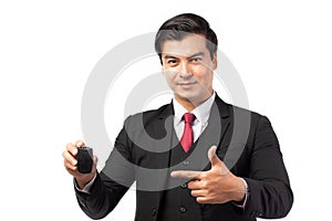 Portrait of a confident business man in black suit feeling happy and smile holding the keys of the car isolated on white