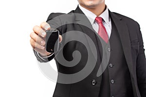 Portrait of a confident business man in black suit holding the keys of the car isolated on white background