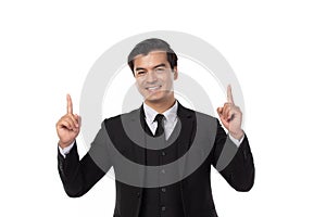 Portrait of a confident business man in black suit smile and pointing to copy space isolated on white background. Portrait