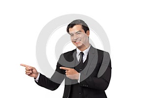 Portrait of a confident business man in black suit smile and pointing to copy space isolated on white background. Portrait