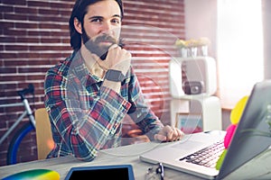 Portrait of confident businessman with graphic tablet and laptop