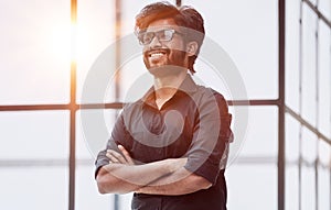 Portrait of a confident businessman standing with crossed arms in a conference room