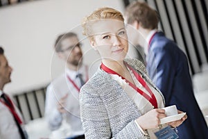 Portrait of confident businesswoman holding coffee cup at lobby in convention center