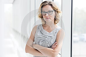 Portrait of confident businesswoman standing with arms crossed at new office