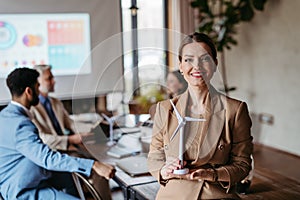 Portrait of confident businesswoman during team meeting.