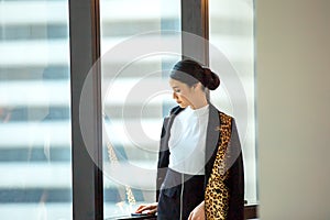 Portrait of confident businesswomen in office looking away by window