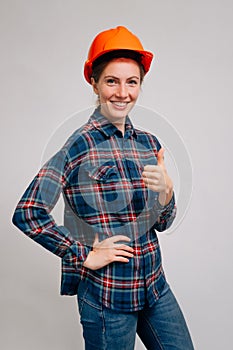 Portrait of a confident cheerful builder woman on a light background,Successful deal concept