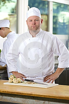 Portrait of confident chef making food in large kitchen