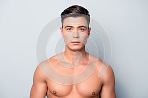 Portrait of confident concentrated handsome muscular with perfect ideal skin shaven guy, isolated on grey background photo