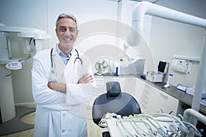 Portrait of confident dentist standing with arms crossed