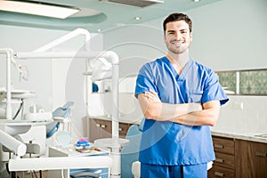 Portrait Of Confident Dentist Standing With Arms Crossed In Clinic