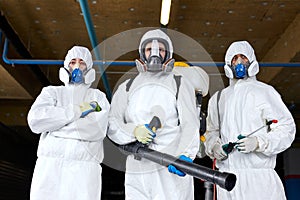 Portrait of confident disinfectants with sprayers