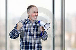 Portrait of confident elderly mature business man giving a speech in megaphone.