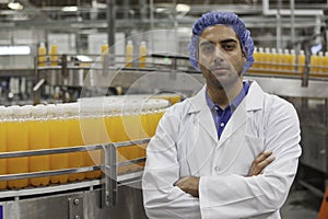 Portrait of confident factory worker standing with arms crossed