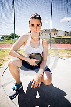 Portrait of confident female athlete holding a discus