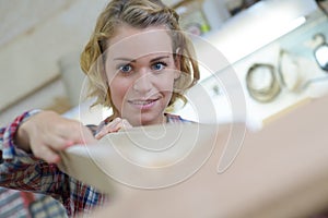 Portrait confident female carpenter measuring drawer in workshop