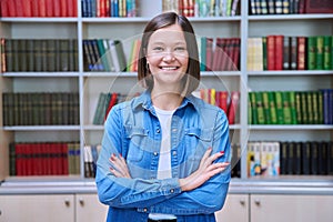 Portrait of confident female college student inside library in educational building