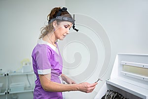 Portrait of confident female doctor. Female ENT doctor in purple medical clothes posing in office of the clinic on her